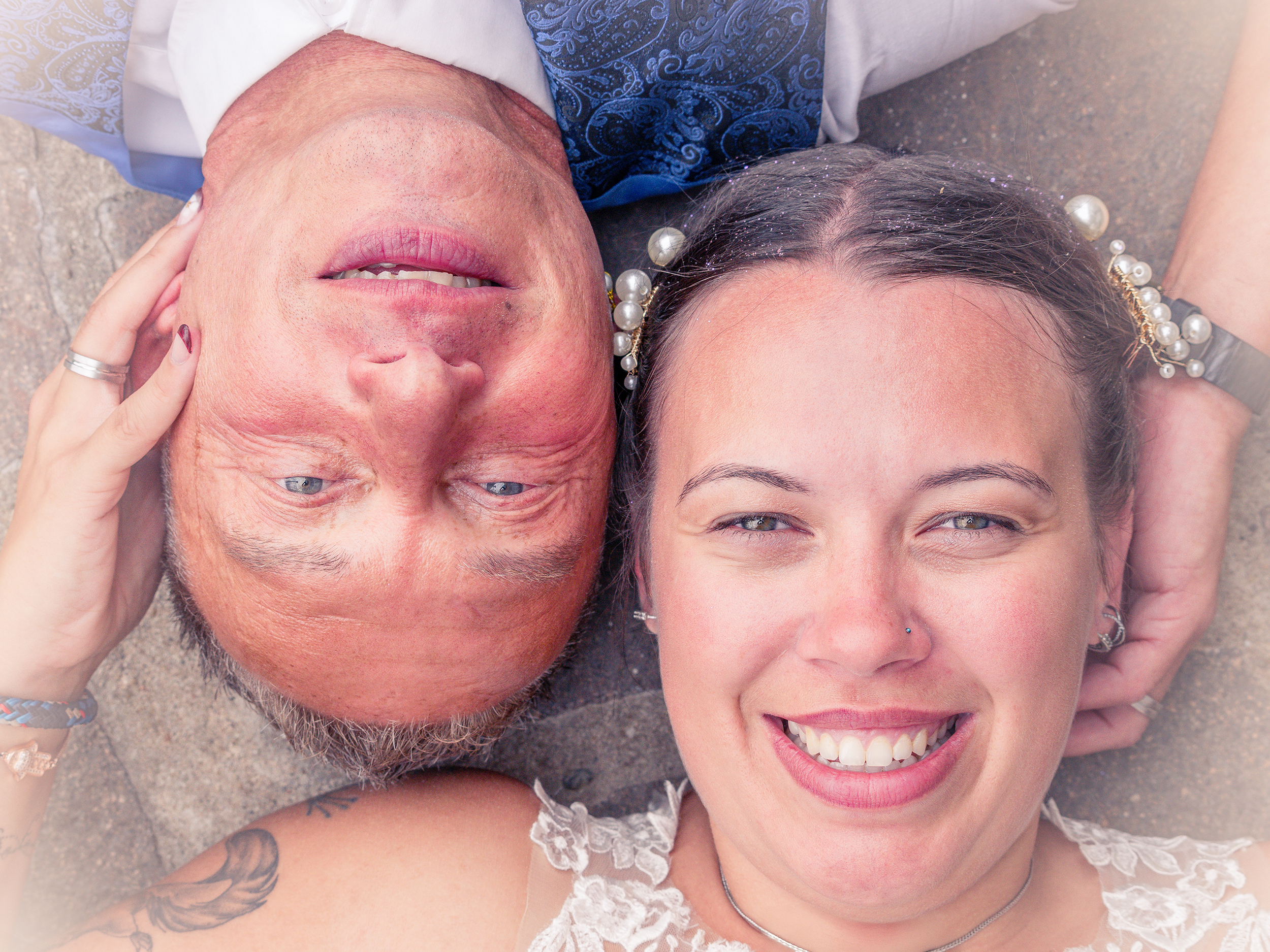 Brautpaar liegt Kopf an Kopf beim After-Wedding-Shooting – Hochzeitsfotografie im Grünen